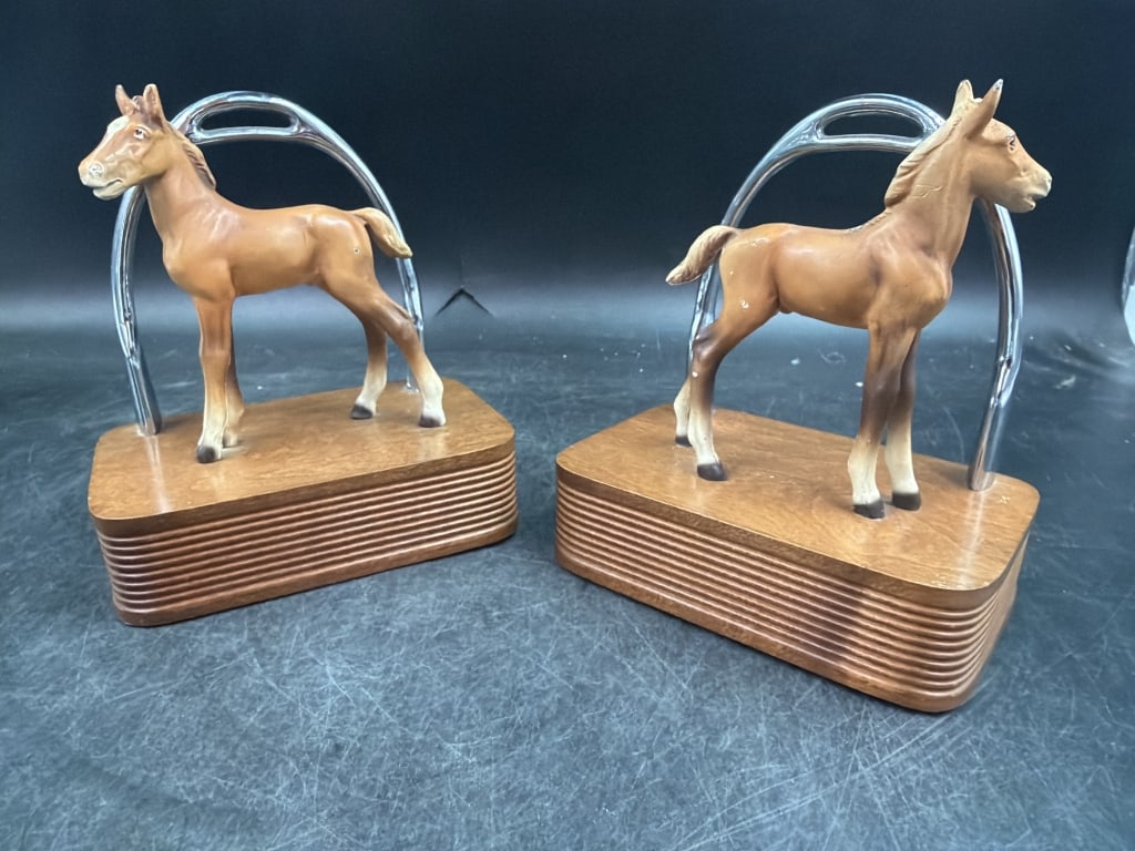 Mid Century 1960's Equestrian Bookends: Neat pair that is horse foal and stirrup bookends. Crafted from cold cast bronze. Multi layered platforms and metallic loops represent classic riding stirrups. Circa 1950-1960. Condition is good.