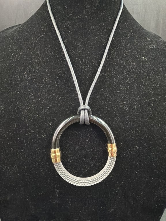 Lalique '1927' Crystal and Resin Cord Necklace: Distinctive piece features the brand's signature Art Deco inspired structural design. Frosted crystal, black resin, gold plated hardware and adjustable leather cord. Condition is good, see pictures. N