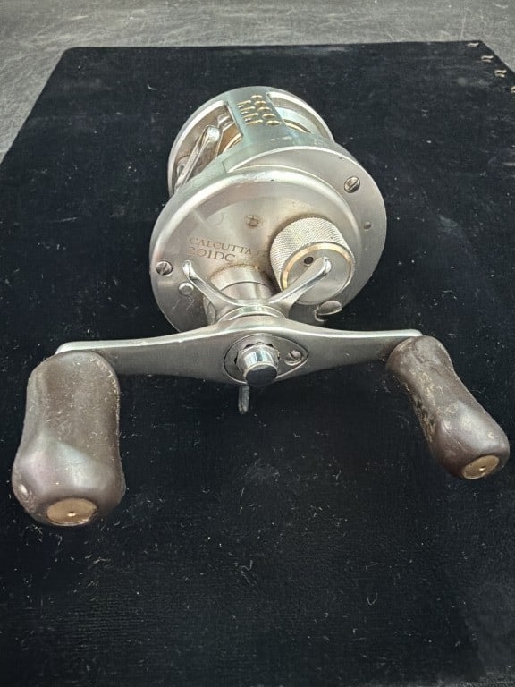 Shimano Calcutta 201DC Baitcasting Reel: Features a distinct cold colored inner spool component. High end metal bodied round reel known for its Digital Control baking systems. Left handed reel that is in good condition, see pictures. No