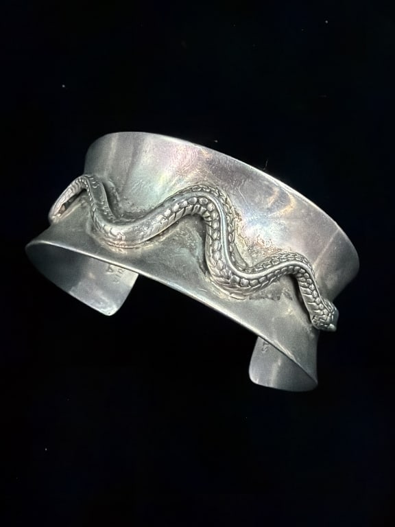 Sterling Native American Cuff 'Signed': Vintage sterling silver wide cuff bracelet with three dimensional slithering snake overlay. Signed by artist Mary Rita Padilla. Weighs 48.7g and cuff 1"w. Condition is good, see pictures. No refunds