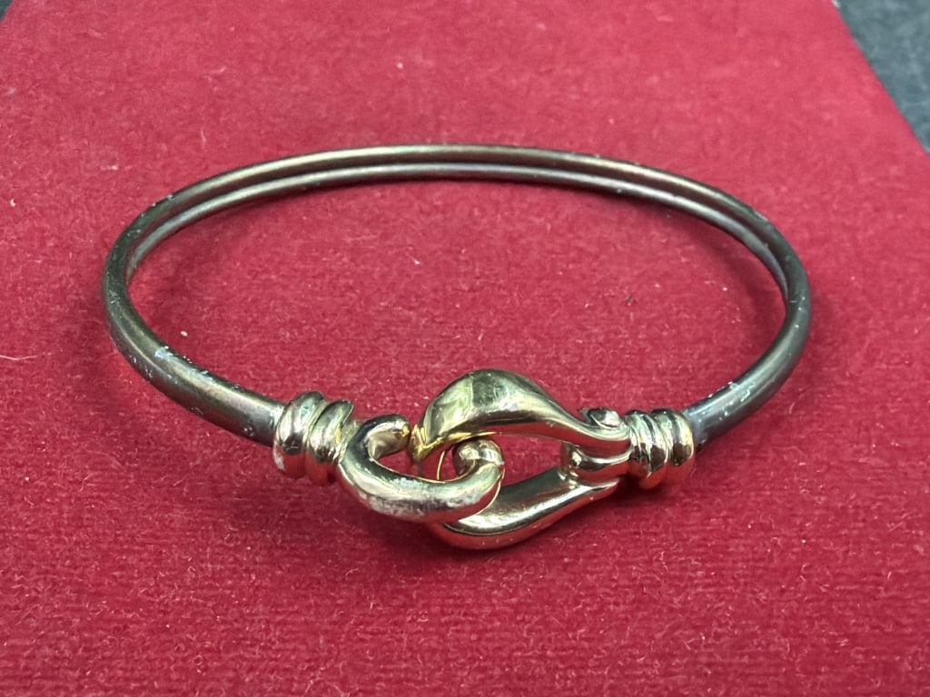 Sterling Silver and 14kt Gold Bangle Bracelet: Features a distinct hook and eye clasp design. Main double wire is 925 and matching 14k gold eye loop . The total weight for this piece is 7.7g and condition is good, see pictures. No refunds given.