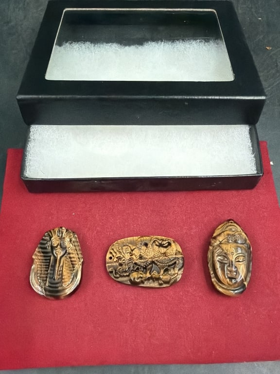 Tiger Eye Pendants: total of 3 in this lot of Tiger Eye. there is a dragon pendant, detailed Buddha head and a Tutankhamun burial mask. About 1.5" each. Condition is good and in small riker case. See pictures. No