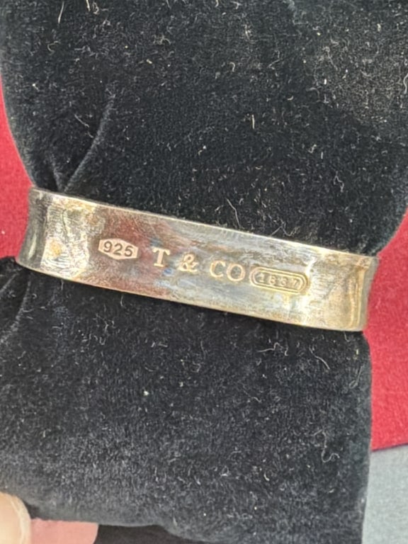 Tiffany and Co Cushion Band: Features a unique square shape bangle. Condition is consistent with age and use, see pictures. Weighs 46.2g. No refunds given.