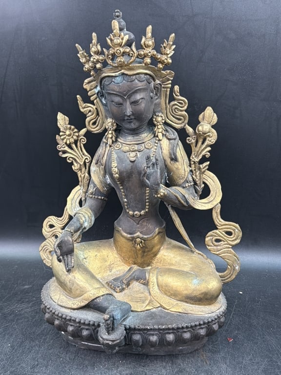 Tibetan Bronze Statue: Unknown age appears to be a representation of Green Tara, decorated with partial gilt highlights. Intricate detailed work and ornate crown with stylized floral elements Measures16" x 11". Condition