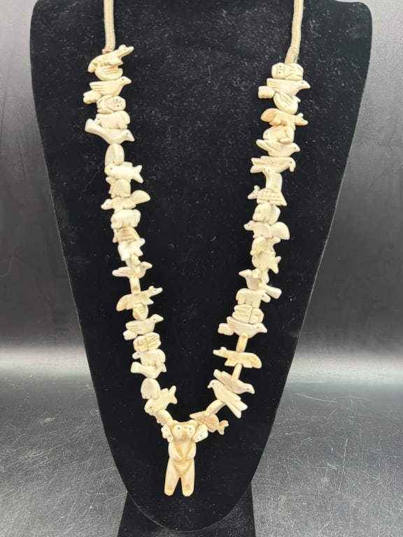 Vintage Zuni Fetish Necklace: Hand carved bone figures of animals birds, rabbits, buffalo, frog, etc. Central figure is a bear. Necklace is squaw wrapped and condition is good. Measures 19" when wearing this piece. See pictures,