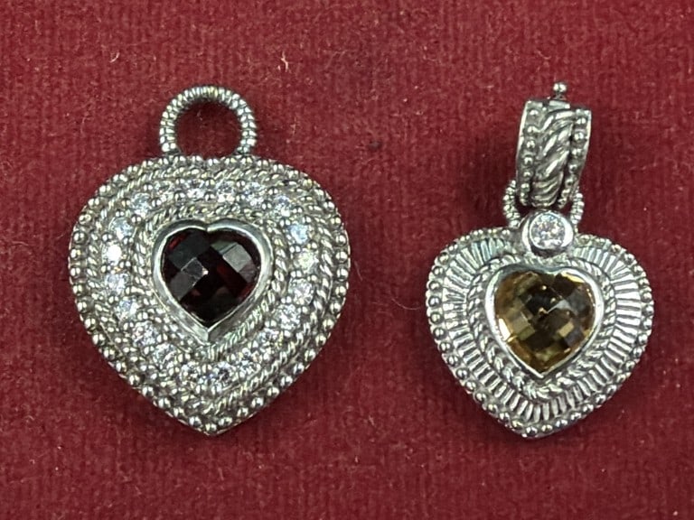Sterling Judith Ripka Silver Heart Pendants: Total of 2 in this lot. One has a garnet and other has a faceted citrine stone. Both surrounded by halo of clear cubic zirconia. Weigh 19.0g. See pictures, condition is good. No refunds given.
