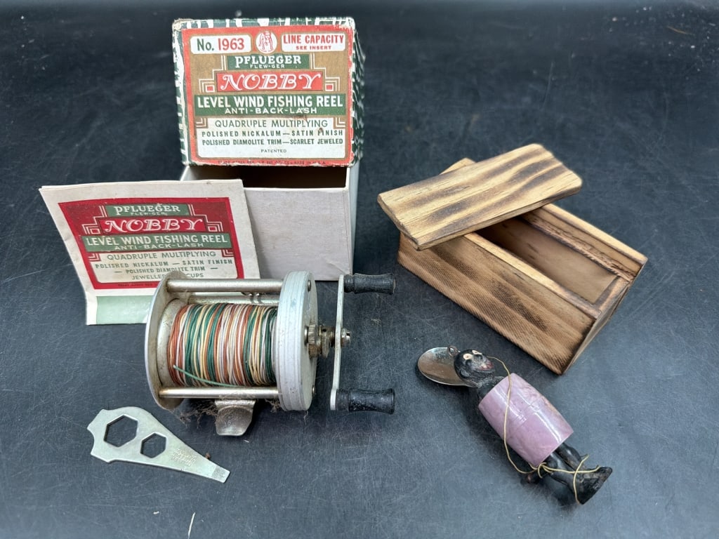 Vintage Fishing Items: One item is a Pflueger Nobby No 1963 baitcasting fishing reel in original box. The other item a Black Americana novelty fishing lure with wood box. Condition appears good, see pictures. No refunds