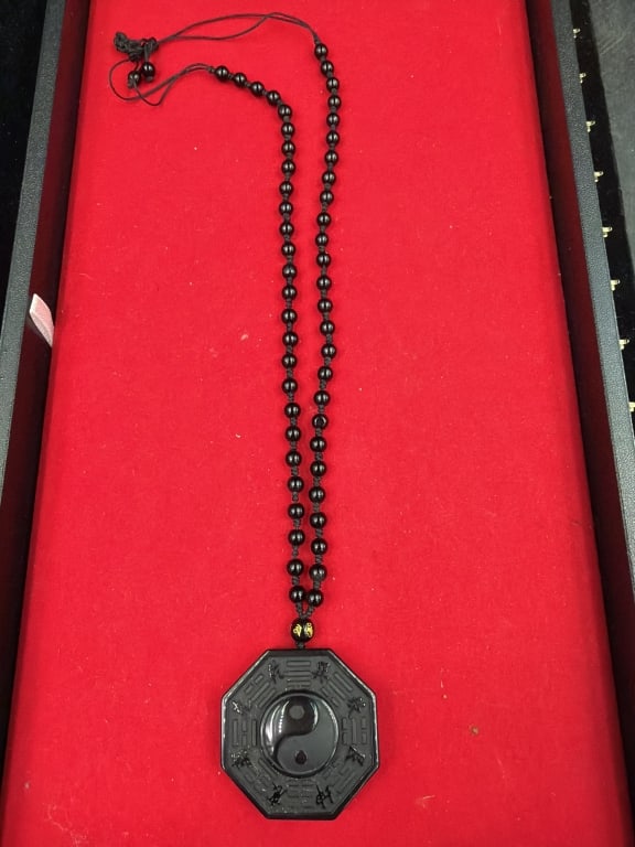 Black Obsidian Yin Yang Ba Gua Pendant Necklace: Features Yin Yang symbol surrounded by eight trigrams of Ba Gua, representing balance and protection. Pendant measures about 5" and 12". Condition appears good. No refunds given.