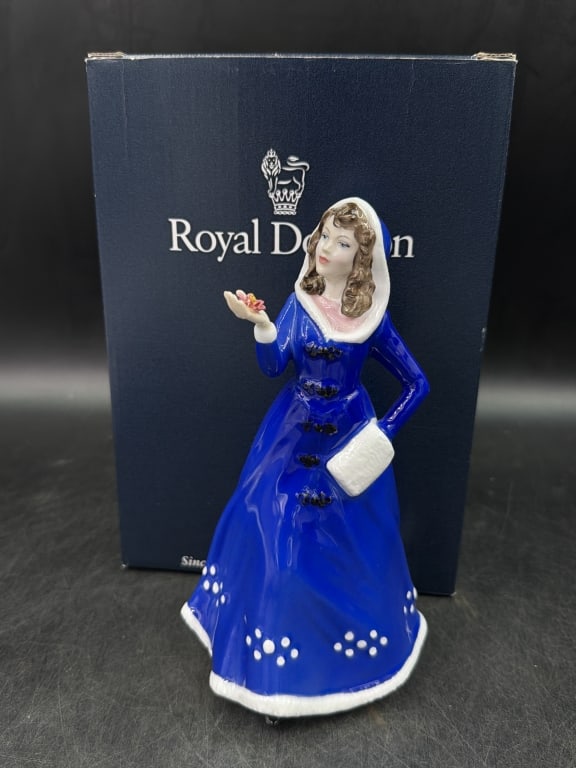 Royal Doulton "First Bloom": Women in cobalt blue dress with white hood and muff. Measures about 8" and has original box. Condition appears good, see pictures. No refunds gi ven.