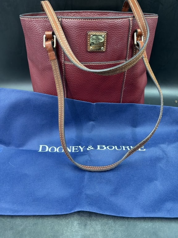 Dooney & Bourke Red Pebble Leather Lexington: Has brown leather straps and a top zip closure. Gold toned log plate on front. Condition is used, but in good condition. See pictures. No refunds given.