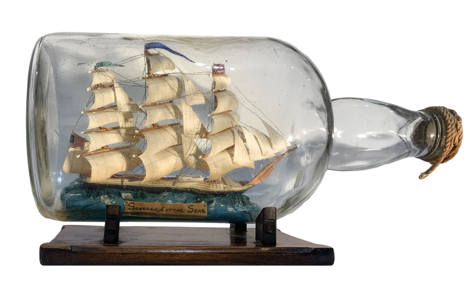 Sailing ship in a glass bottle, with a wooden base.: Sailing ship in a glass bottle, with a wooden base. 20th century. Cm 20x37.