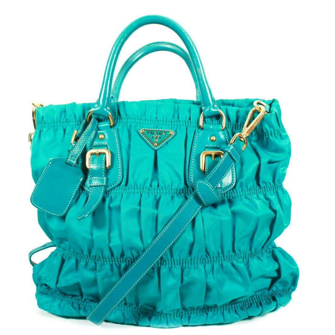 Prada - Tall Tessuto Shoulder/Crossbody Tote Bag: Prada - Tall Tessuto Shoulder/Crossbody Tote Bag Color: Teal blue Size: Medium - Tall Material: Leather ------------------------------------------------------------ Details: - handles and adjustable, 