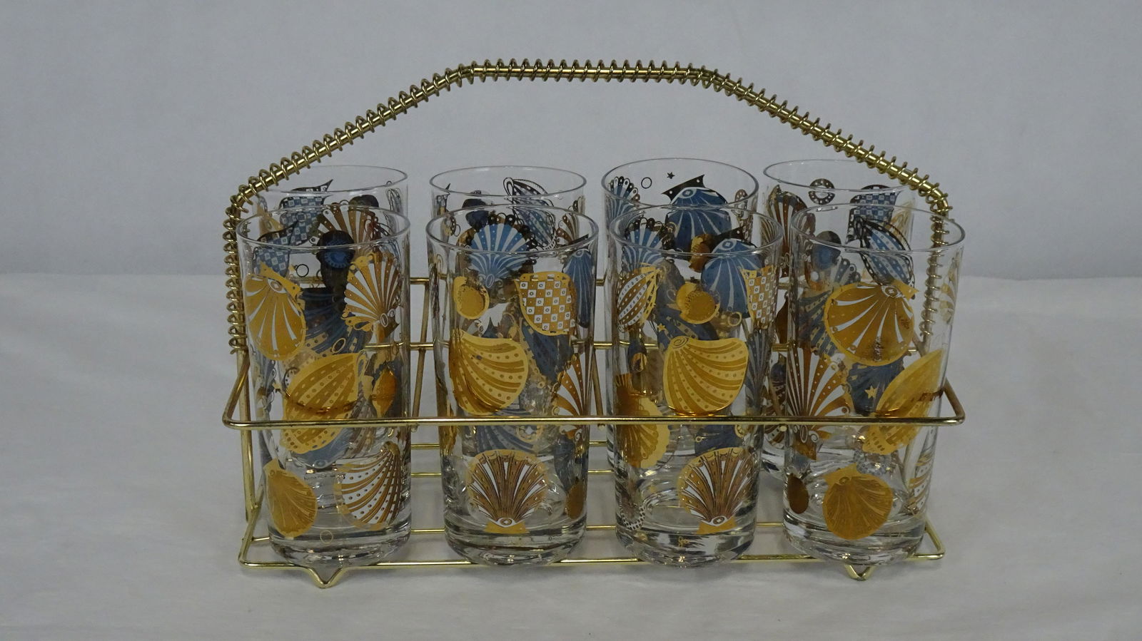 Mid Century Georges Briard 24kt Barware Glasses: Mid Century Georges Briard 24kt Barware Glasses with Seashell Design. Eight Glasses in Holder. Georges Briard Signature on Each Glass. 5.5"H in Good Condition.