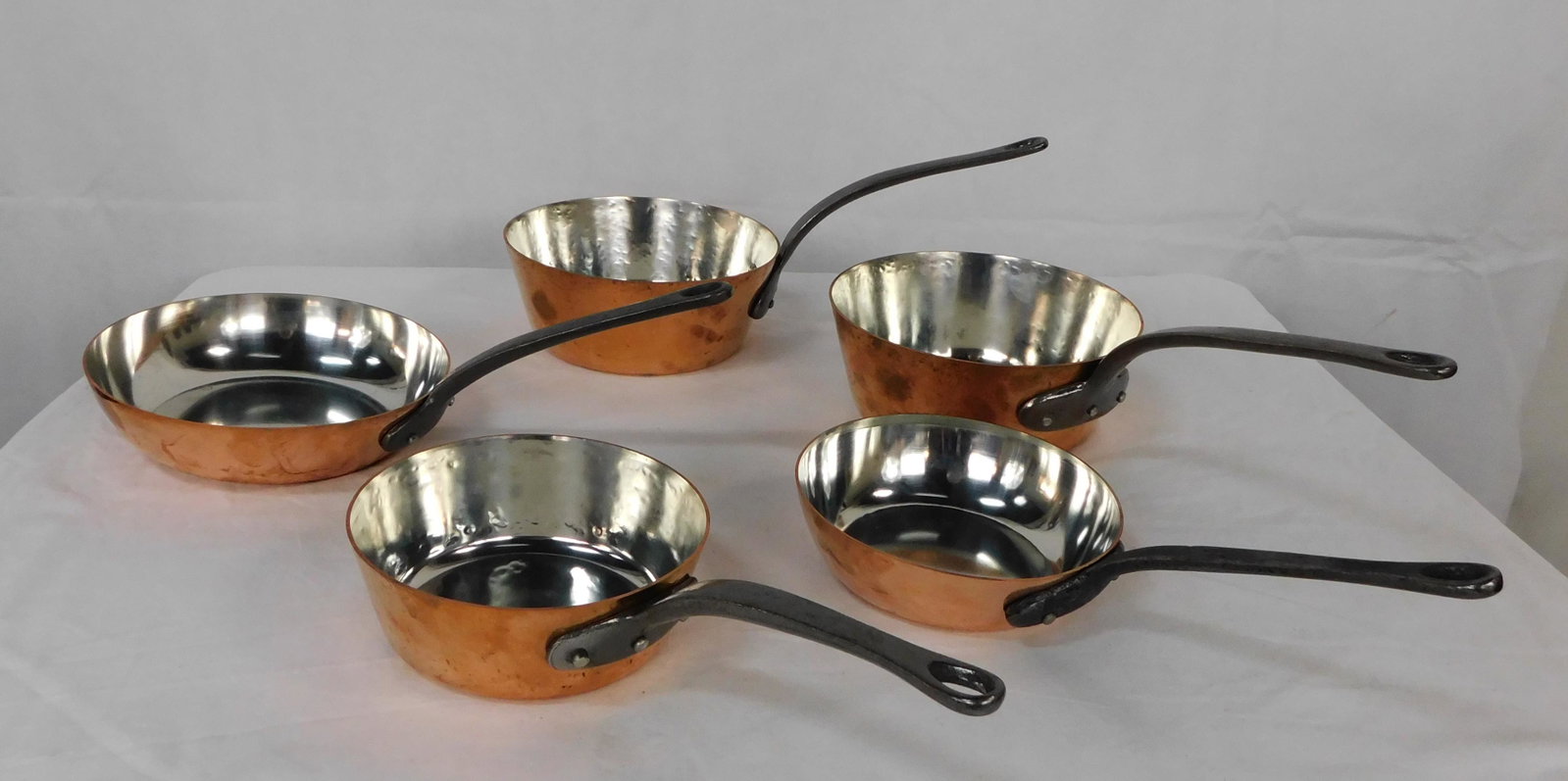 Set of Baumalu Tin Lined Copper Cookware French: Set of Baumalu Tin Lined Copper Cookware French in very good condition, 5 total pieces, all tin in good shape, cast iron riveted handles, 2 8'' Saucepans, 2 6.5'' Pans, 1 8.25'' Pan