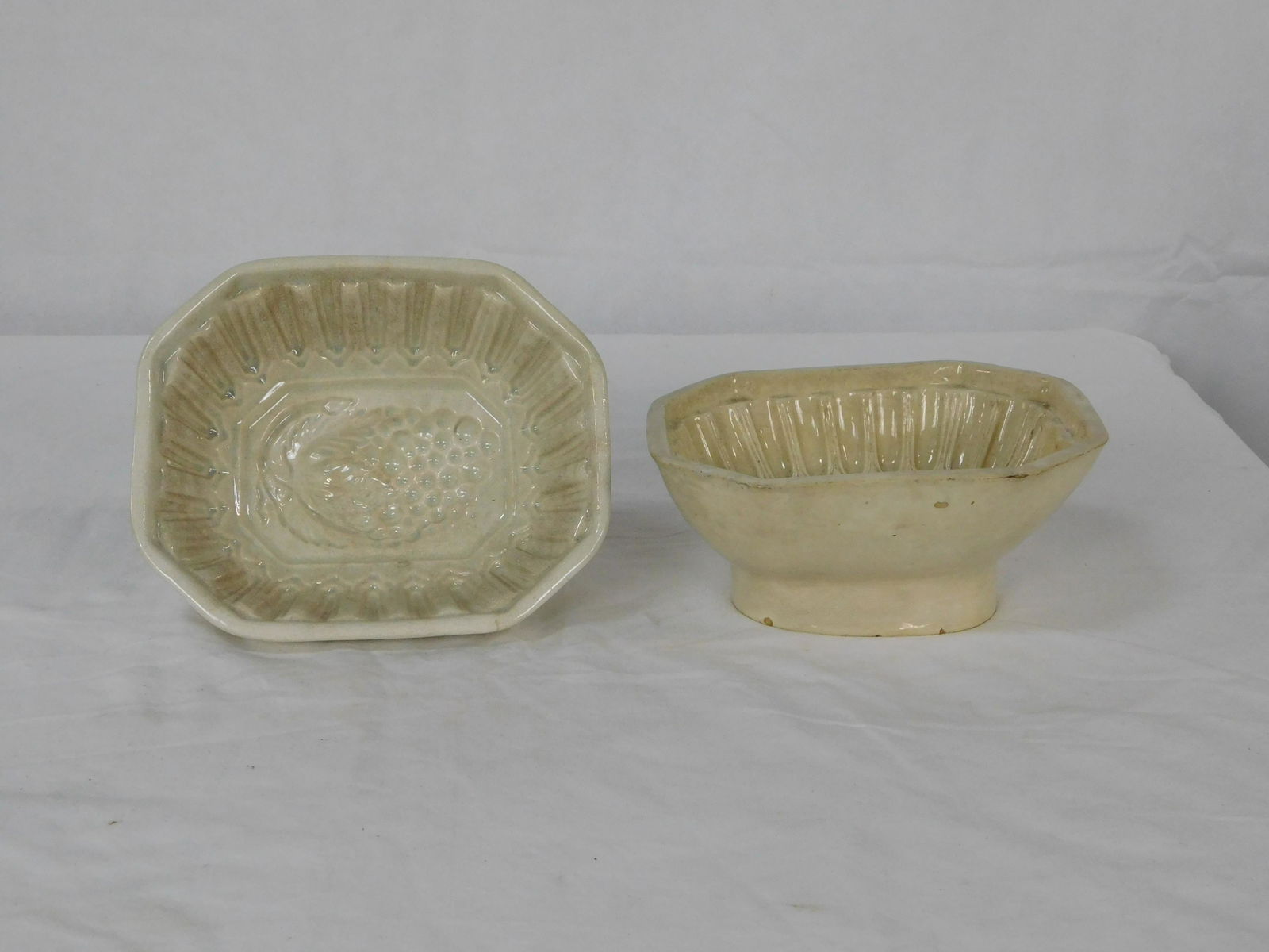 2 Early Ironstone Molds: 2 Early Ironstone Molds in good condition with some chips consistent with age, Grape pattern in one mold, Pineapple in the other mold, both have crazing, 3.75''H x 8.5''W x 7.25''L
