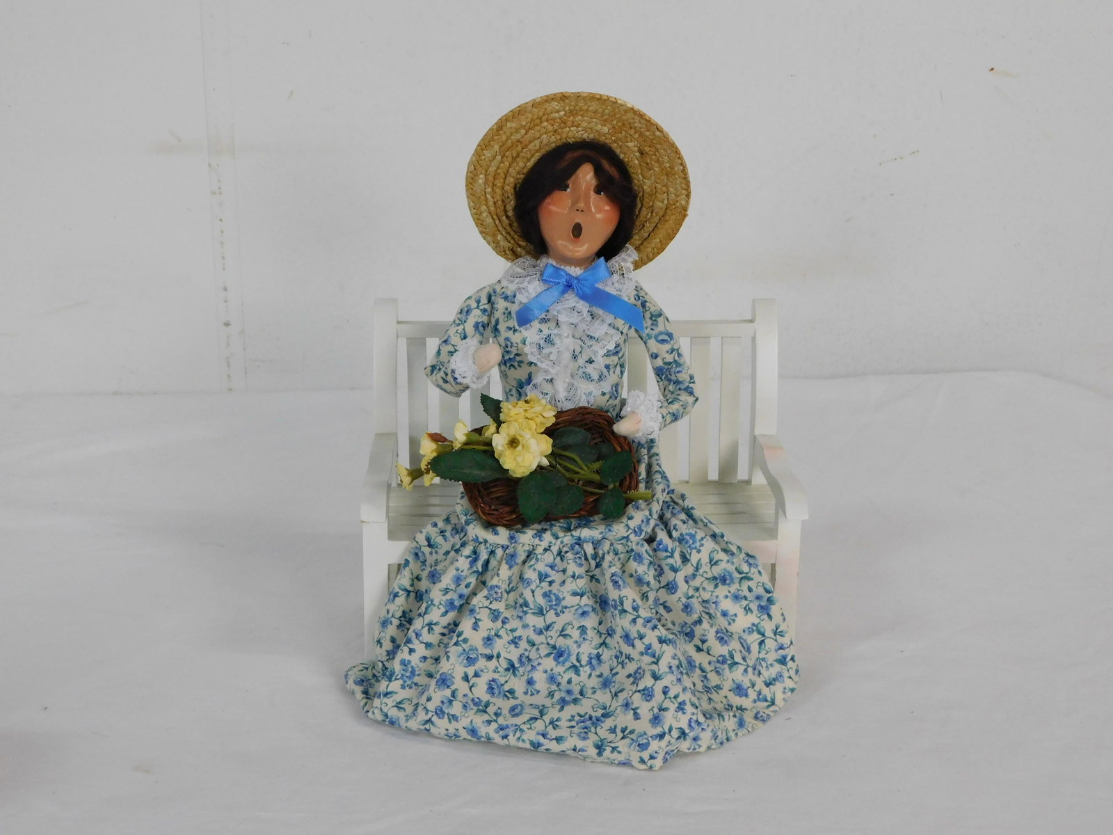 Byers Choice Spring Caroler Woman on Bench 2005: Byers Choice Spring Caroler Woman Sitting on Bench 2005. 10.5" tall in good condition with small red stain on arm of bench as pictured.