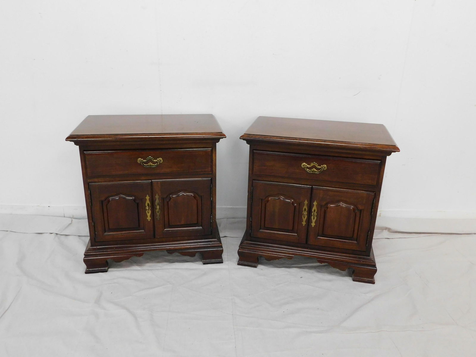 Pair of Thomasville Cherry Nightstands: Pair of Thomasville Cherry Nightstands in good condition, brass hardware, Dovetailed drawers, 25.5''H x 25''W x 16''D ***Auctioneers Note*** This is part of a bedroom suite, to bid on matching items c