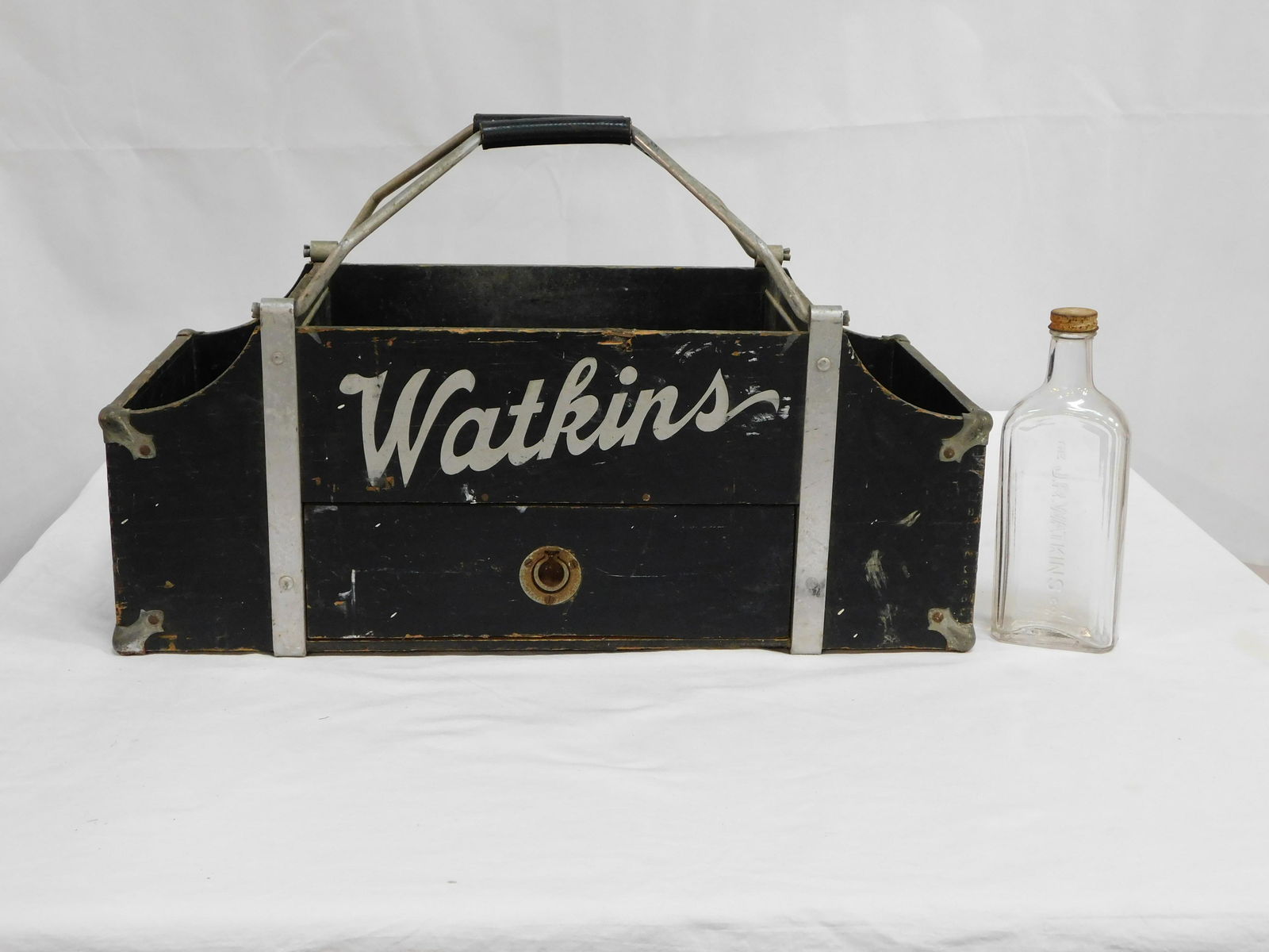 Old Rare Wooden JR Watkins Salesman Box Tote: Old Rare Wooden JR Watkins Salesman Box Tote including Old Watkins Bottle with Lid. Condition commensurate with age, see pictures. Metal straps with handles and metal reinforces corners, Watkins logo