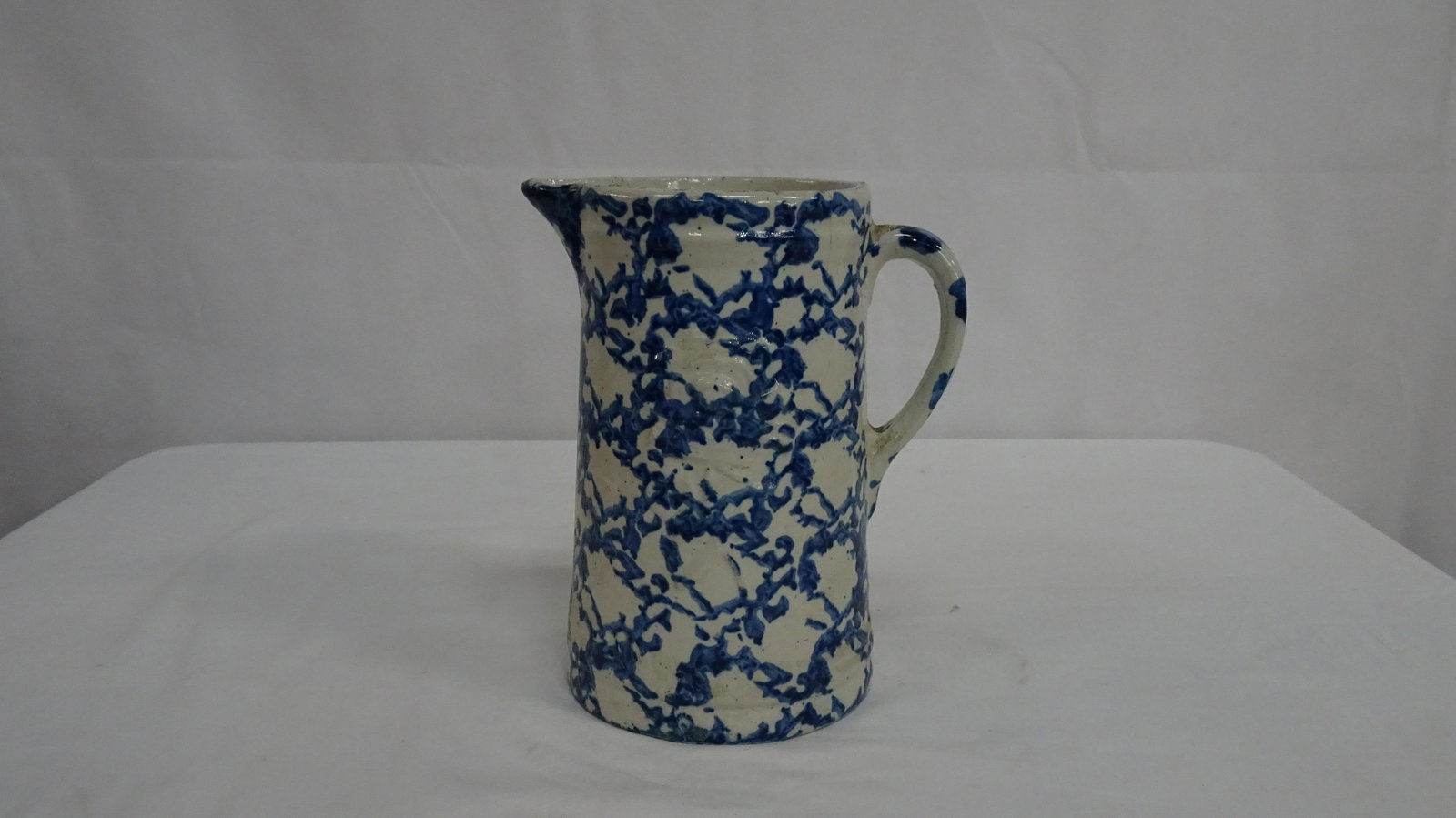 Vintage Blue & White Spongeware Crock Pitcher: Vintage Blue & White Spongeware Crock Pitcher in good condition with some rim chips and age lines from use. Both sides have an embossed rose. 9"H