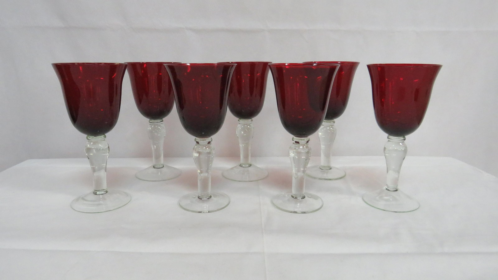 7 Ruby Red Wine Glasses with Clear Stems: 7 Ruby Red Wine Glasses with Clear Stems in good condition. 7.5"H