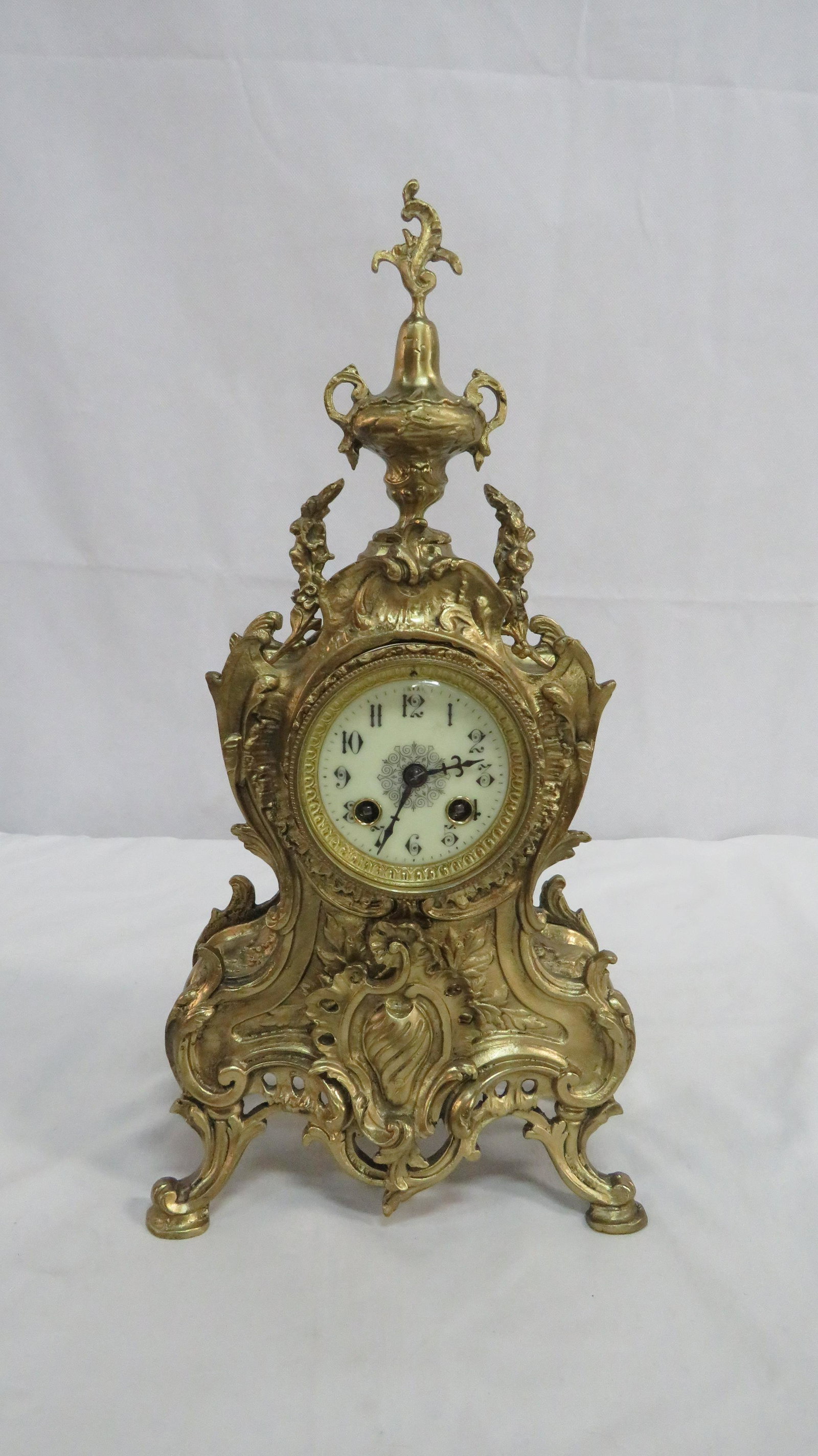 Rococo Style Brass Clock A D Mougin Movement: Rococo Style Brass Clock A D Mougin Movement. Works may not be original to the clock case. Movement is marked with the A D Mougin Medallion. Running when cataloged. Sold with no warranties or guarante