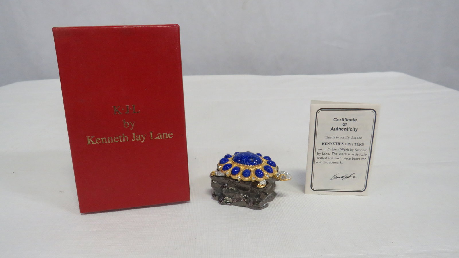 Kenneth Jay Lane Turtle Brooch Trinket Box: Kenneth Jay Lane Turtle Brooch Trinket Box Costume Jewelry in good condition. Original box with Certificate of Authenticity. Turtle brooch with crystals and faux blue lapis.