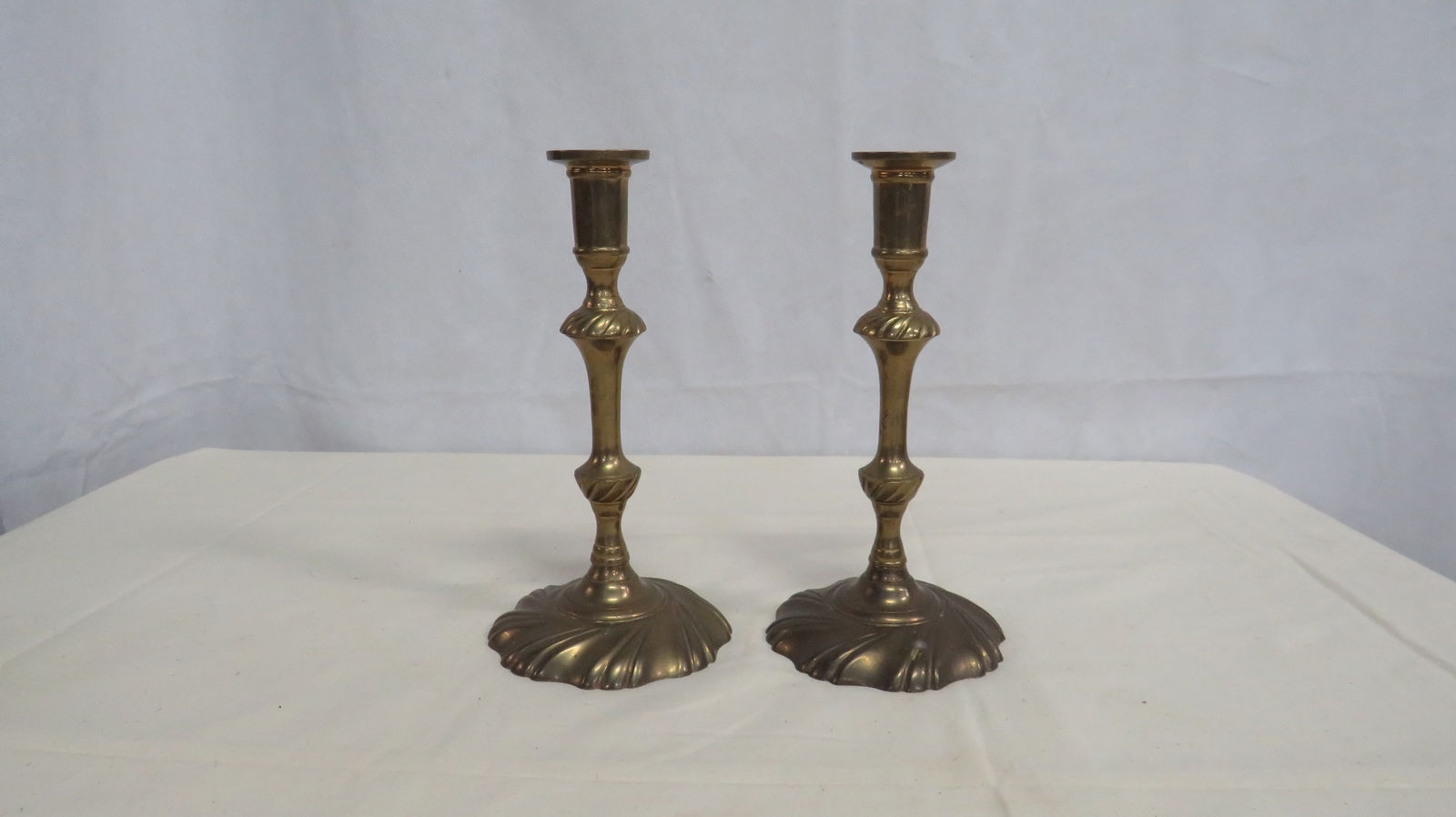 Pair Mottahedeh Brass Winterthur Candlesticks: Pair Mottahedeh Brass Winterthur Candlesticks in good condition. Done in Colonial Williamsburg style for Winterthur Museum Collection. Maker's logo on the underside. 9"H x 4.75" base.