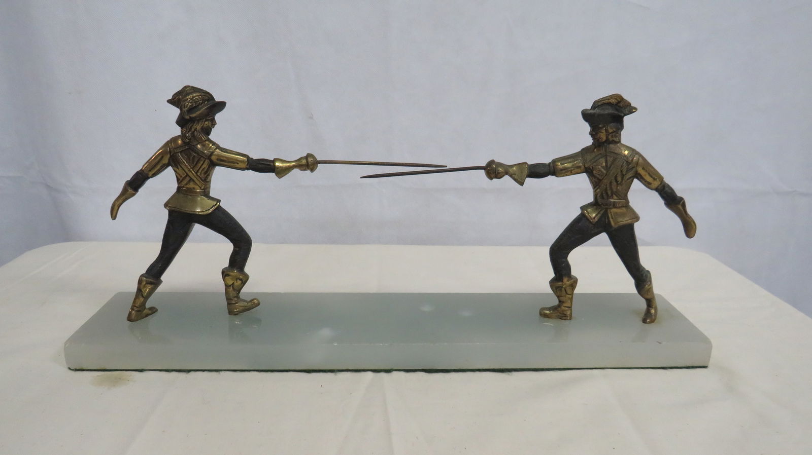 Mid Century Italian Duelling Muskateers Sculpture: Mid Century Italian Duelling Muskateers Sculpture on Onyx Base in good condition. Charming mid-20th-century decorative sculpture featuring two Renaissance-style muskateers engaged in a fencing duel. T