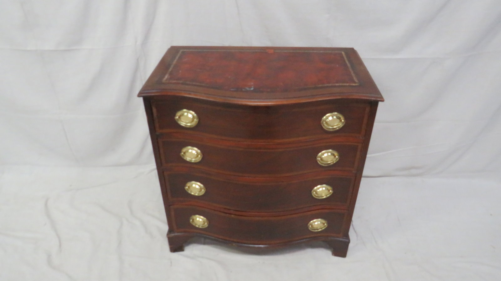 Antique Mahogany Serpentine Leather Top Chest: Antique Mahogany Serpentine Leather Top Chest in good condition, shows signs of wear, Dovetailed Drawers with Brass Hardware, 31''H x 30.5''W x 18.5''D