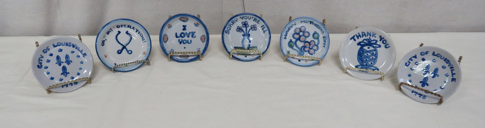 Group of Seven Hadley Pottery Trinket Dishes: Group of Seven Hadley Pottery Trinket Dishes in good condition. Six have different designs, two commemorate the founding of Louisville, KY. 4.5" diameter