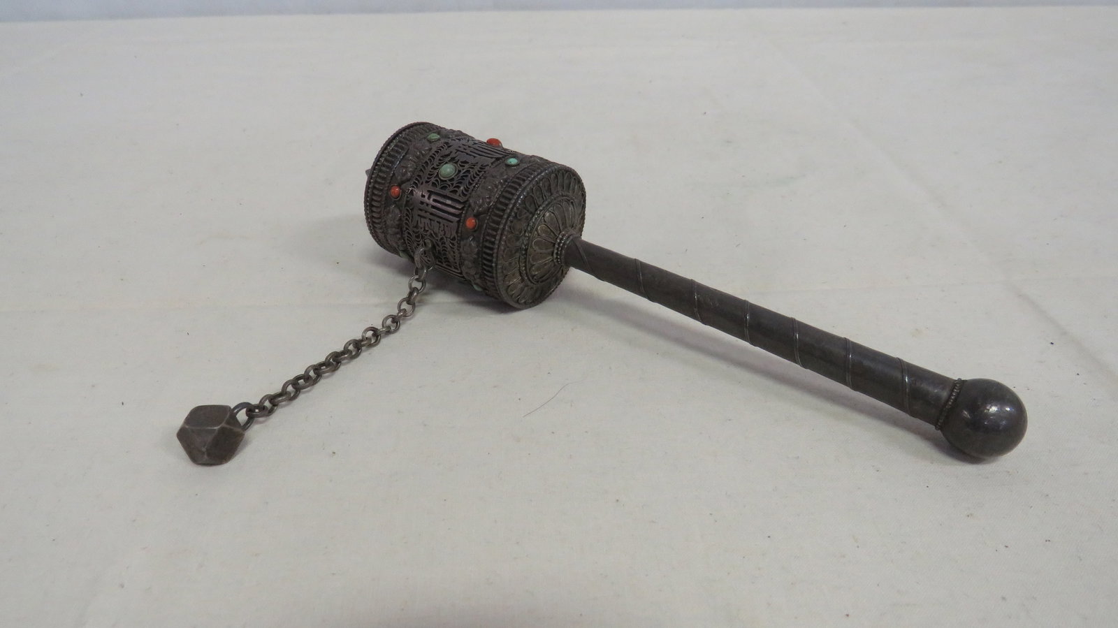 Tibetan White Metal and Hardstone Prayer Wheel: Tibetan White Metal and Hardstone Prayer Wheel in good condition. 20th century cylindrical filigree metal body set with cabochon stones in red and green tones. Mounted on a turned handle with attached