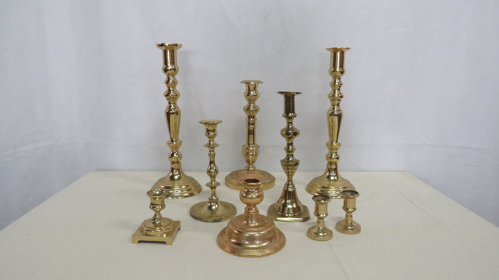 Group of 9 Vintage Solid Brass Candlesticks: Group of 9 Vintage Solid Brass Candlesticks in good condition. One smaller one is gold plated. Measure 2.5" to 13" tall.