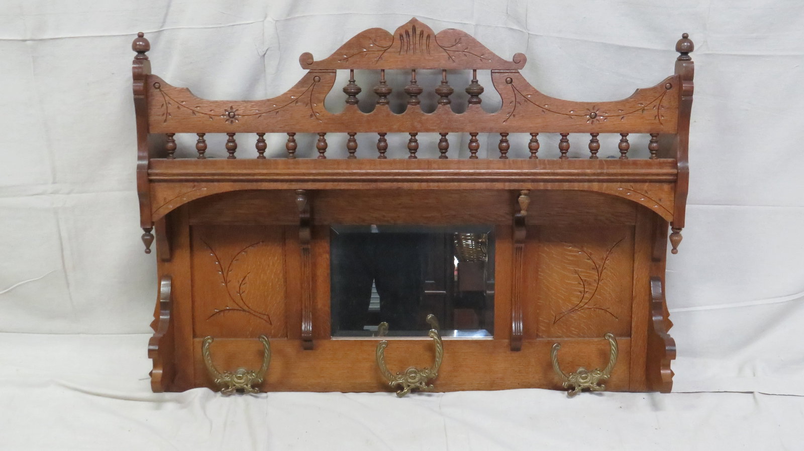 Antique Carved Oak Mirrored Hall Rack: Antique Carved Oak Mirrored Hall Rack in good condition. Likely a pump organ top repurposed as an entryway hanging piece for hats and coats. Style and age appropriate double brass hooks attached.