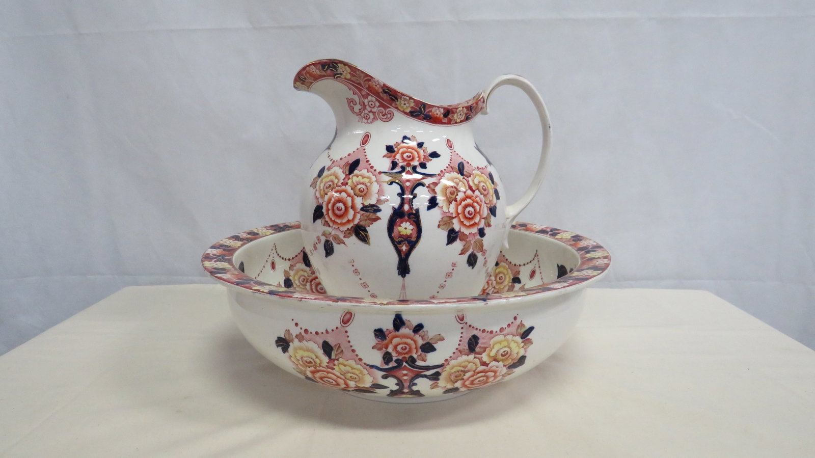 Victorian Polychrome Staffordshire Wash Set: Victorian English Staffordshire matching ewer and wash basin, mid 19th century, decorated in richly colored polychrome transfer pattern with hand-colored accents in the Imari taste. Unmarked in good