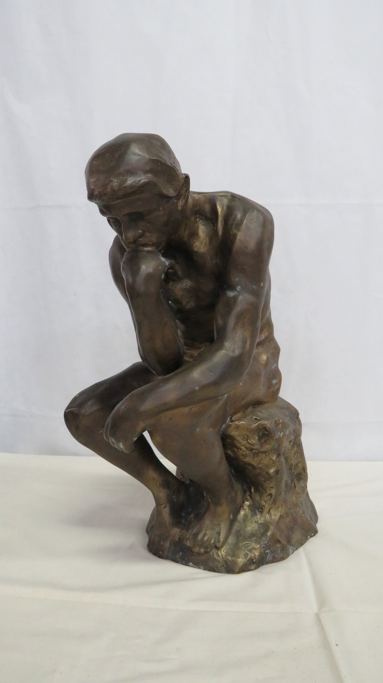 Antique Bronze Sculpture "The Thinker": Antique Bronze Sculpture After Rodin's "The Thinker". Large scale sculpture modeled after Rodin's Le Penseur (The Thinker). The figure is depicted in a seated contemplating pose upon a naturalistic