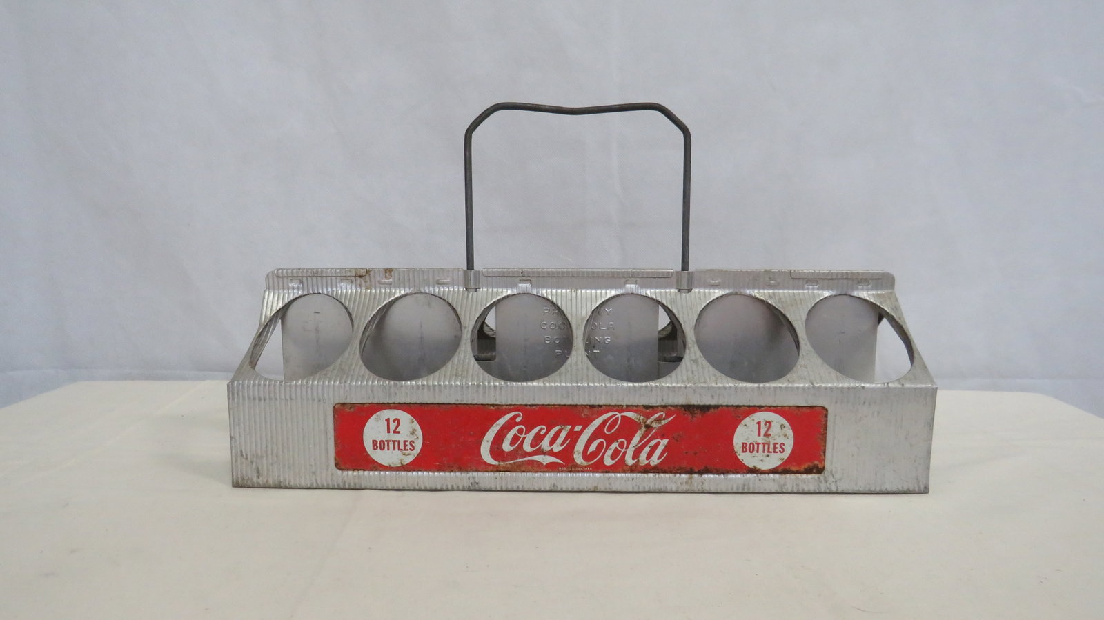 Mid Century Aluminum 12 Bottle Coca-Cola Carrier: Mid Century Aluminum 12 Bottle Coca-Cola Carrier. Holds 12 bottles, Good condition with some light rust. 5"H x 16.25"L x 5.5"W with 4"handle.