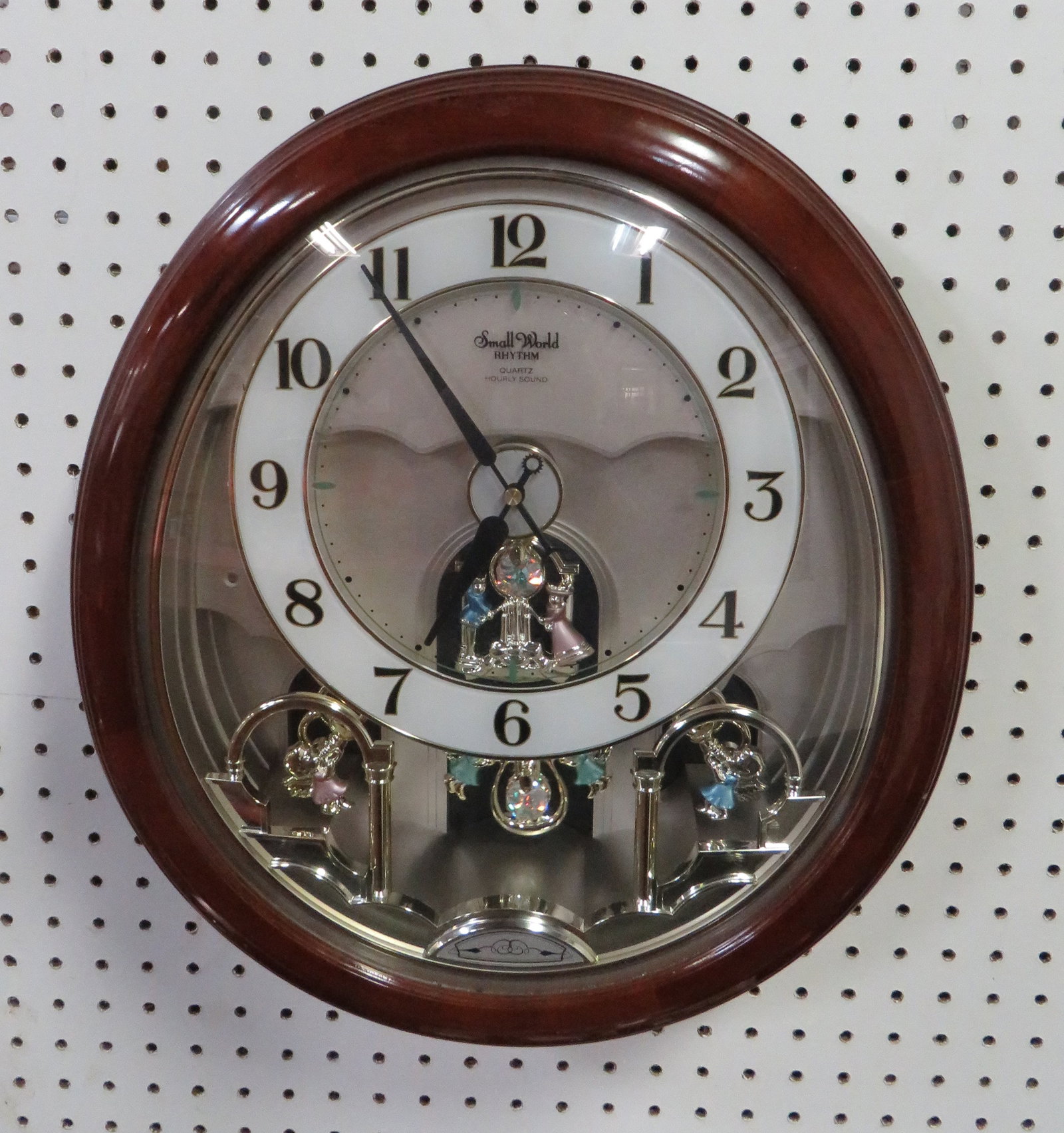 Rhythm Small World Motion Clock Swarovski Crystal: Rhythm Small World Motion Clock with Swarovski Crystal on the pendulum. Clock rotates and cherubs move upward while playing different melodies on the hour. Good condition. 17.5" x 16"