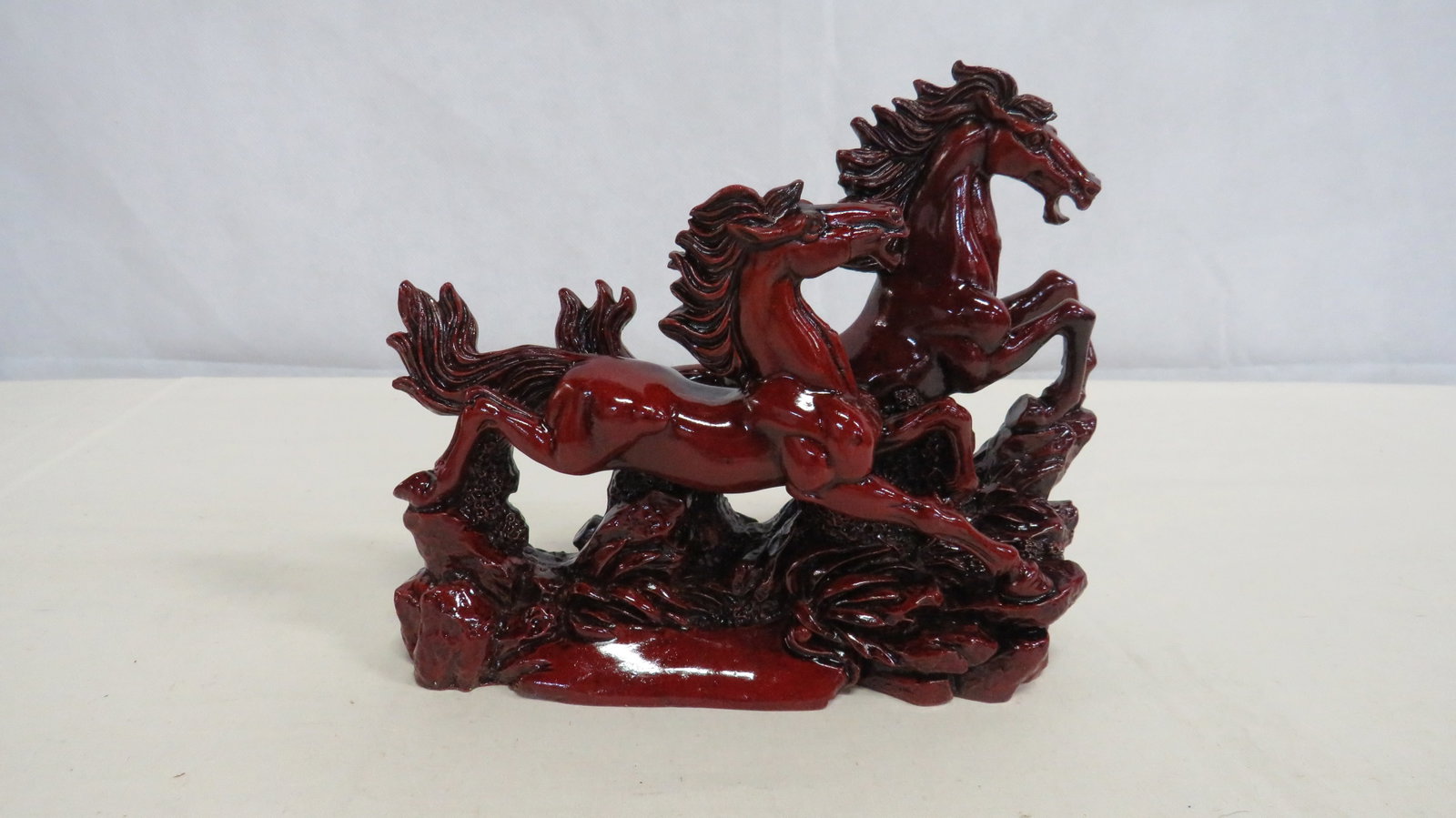 Galloping Horses Statue in Deep Red Finish: Decorative Asian-influenced molded sculpture depicting two galloping horses with a rich deep red laquer-style finish. 6.75"H x 8"L x 3"W