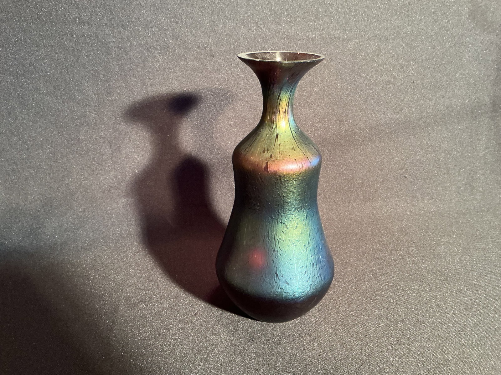 In the manner of Loetz Green Studio Glass Vase: Green Studio Glass Vase with squeezed bulbous body graduating to a tapered neck and flared lip. No mark found.
