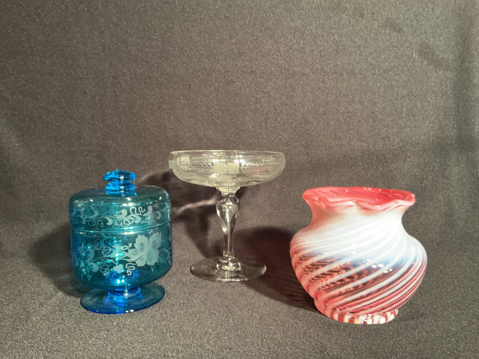 Three piece Art Glass Group: Hawks blue etched lidded jar - 5.5", Clear Etched compote Irish Rose design - 6", Fenton Cranberry opalescent vase - 5"