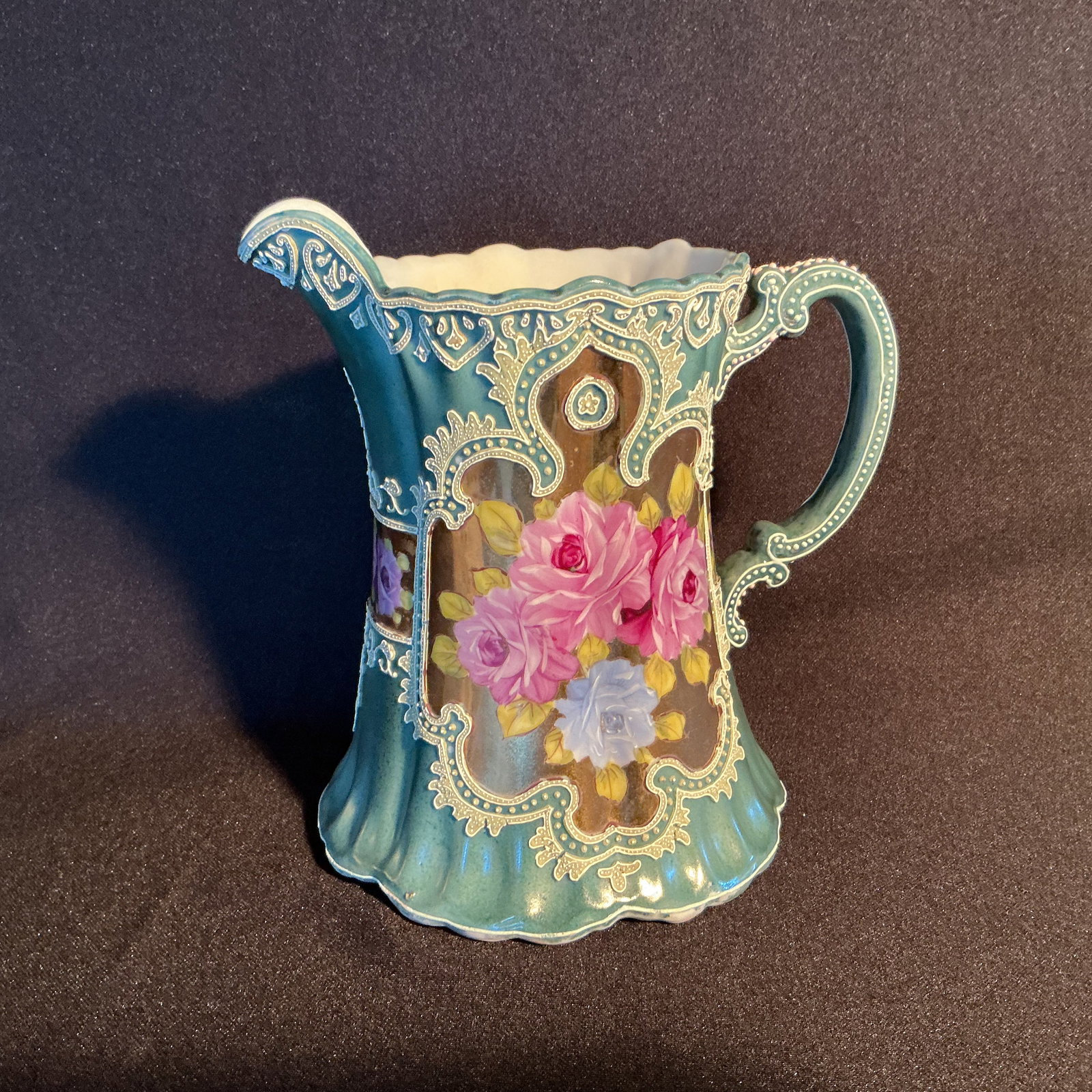 Nippon Moriage Pitcher: Nippon Moriage Pitcher with bluish green ground highlighted with textured squeeze box and painted pink and blue roses in central panels.