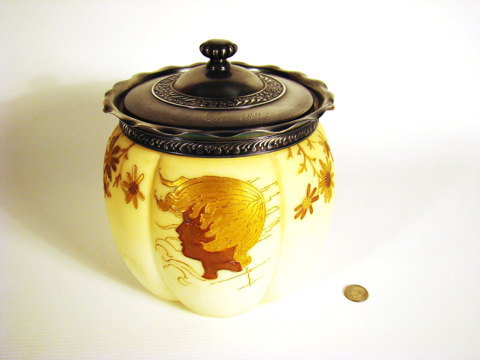 Wavecrest Biscuit Jar with Silouette: Wavecrest Biscuit Jar with Silouette on front in golds and browns and foliate flower designs around sides. The silver mounts and lid are stylized art nouveau designs. Lid has "Sue 1892" engraved in