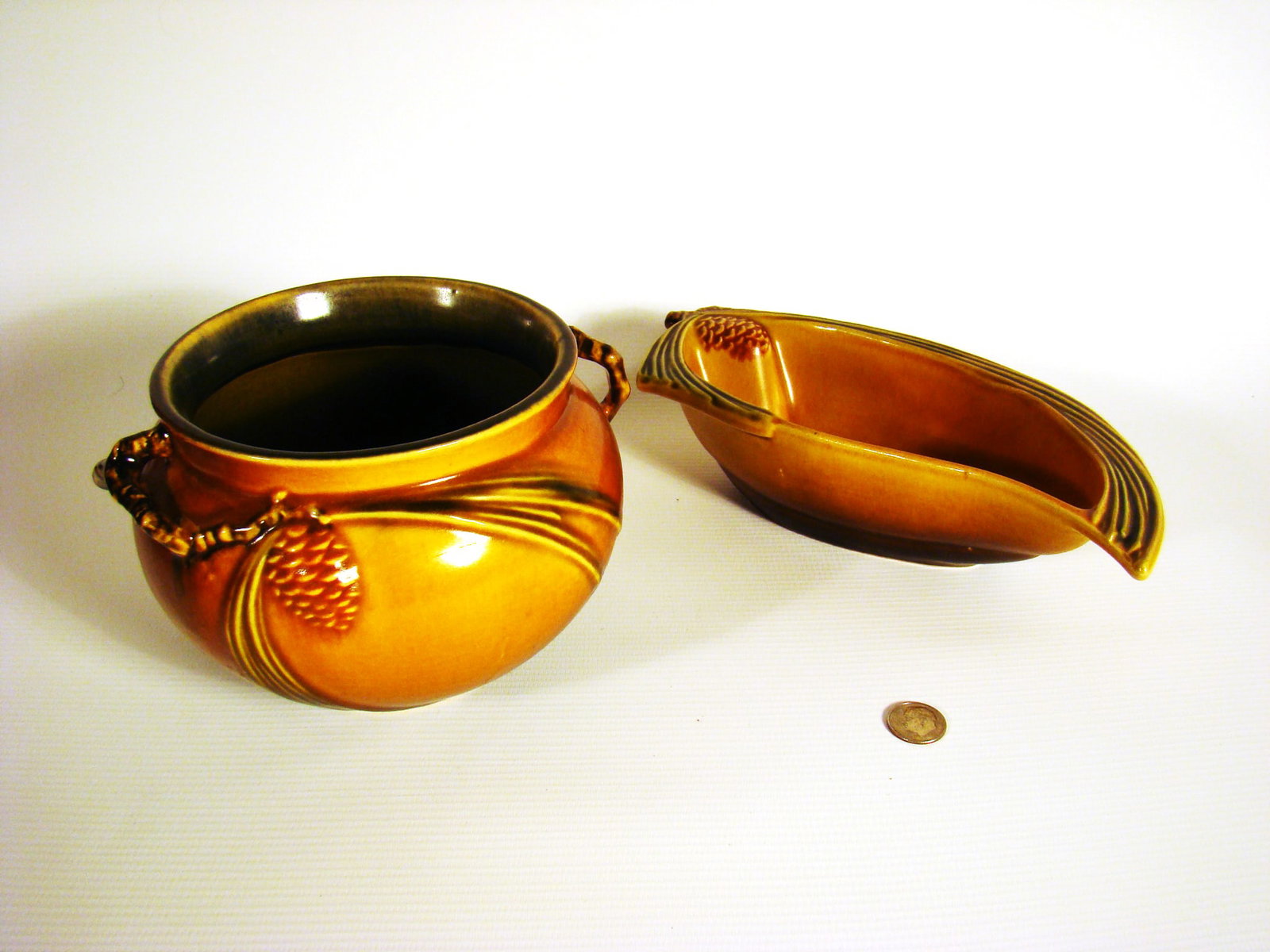 Two pieces of Roseville Pinecone: Two pieces of Roseville Pinecone. a double handled bowl and a low arched needle shaped dish.