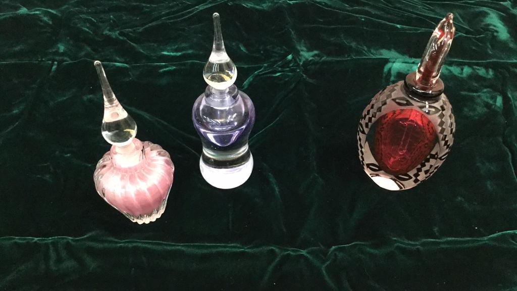 Three Art Glass Perfume Bottles: 6 inch pink swirl and 6 1/2 inch purple shaded both with tear drop stoppers, both signed Vandermark dated 1982...6 1/2 inch Harlequin pattern bottle with ruby interior, loop dauber, artist signed not