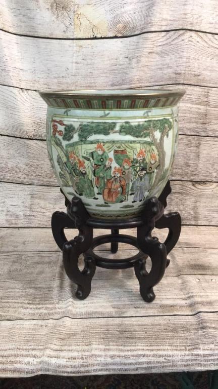 Large Asian Fishbowl Planter: 12 inches tall..flared rim..interior with goldfish and fern...2 panels show warriors and elders , side panel decorative of butterflies and flowers..with a separate wood stand...good condition ..4 char