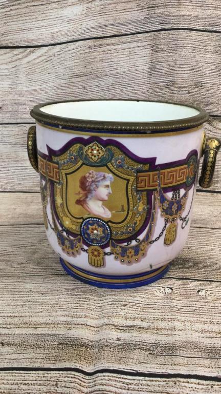 Porcelain Cachepot w/ Greco Roman Design: 10 x 12 inches with brass collar...enameled portrait front panel with Greek key, drape and tassel, ring handles....reverse design of grapes....old staple repair to body..still beautiful