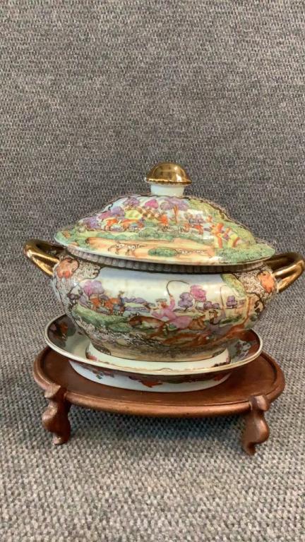 Asian Porcelain Tureen on Stand: 14 x9 inch tureen with under plate, decorative designs of hunting scenes, gilt handles and finial, seperate oval wood stand...
