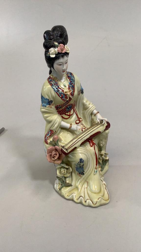 Porcelain Figural of Geisha Plying Instrument: 10 inches tall, glazed bisque with lovely detail to hands, hand painted face….unsigned