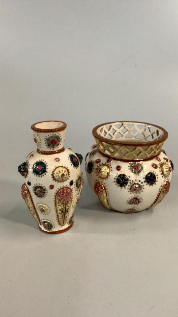 2 Pieces Art Pottery, Minton?: 7 inch vase with a narrow neck….relief decoration to body….5.5 x 6 inch round vase with reticulated neck band, similar designs to body…both in multiple colors on a cream body…both pieces with 
