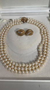 14K Gold and Pearl Ensemble: 20 inch ..3 strand of cultured pearls with a gold and Diamond Clasp in a Fleur de lis pattern, pair matching 14k gold and Diamond set earclips